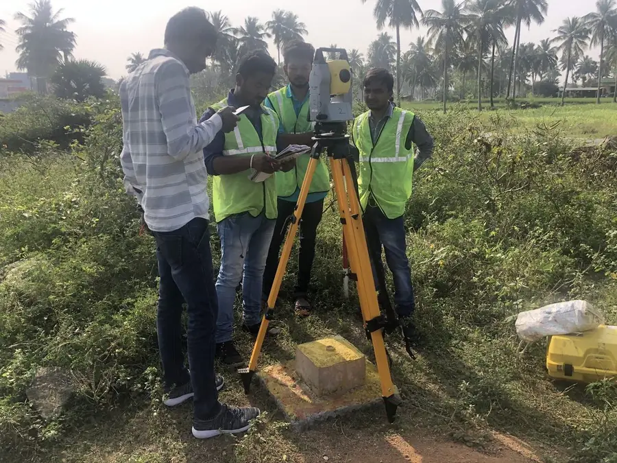 BTPL survey crew observing over a benchmark pillar during a topographic survey.